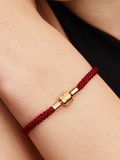 Skinnende rødt armbånd med snor